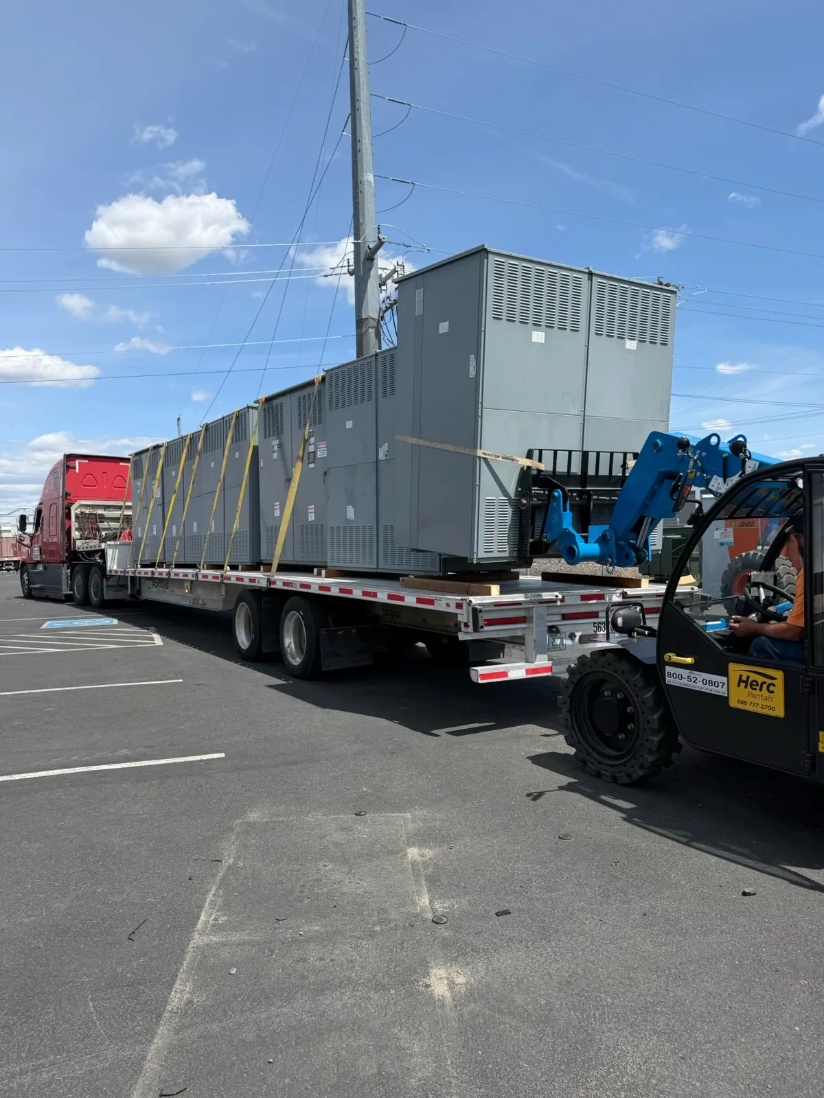 Switchgear sections loaded on a flatbed with a telehandler — Tulsa, OK