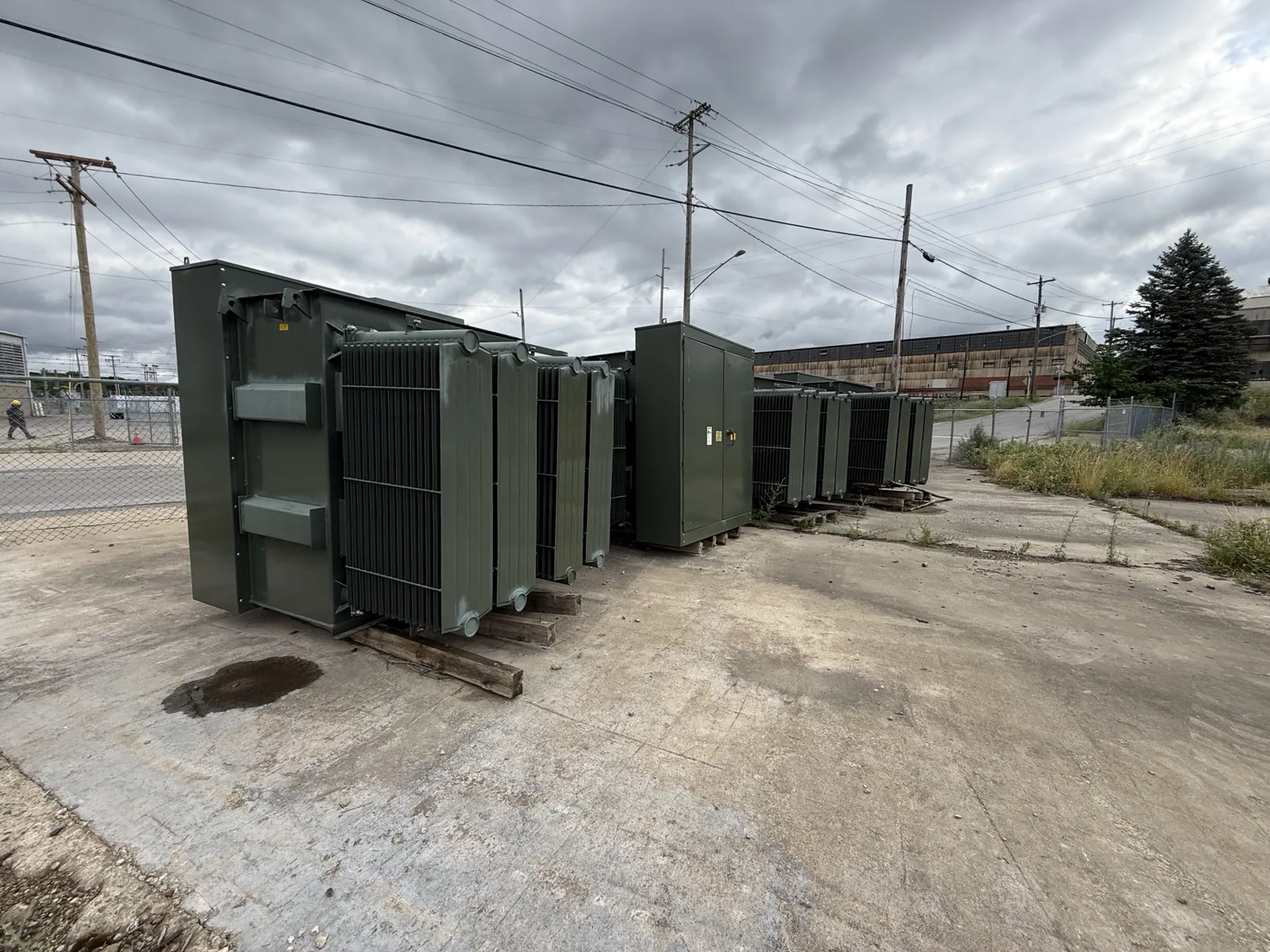 Row of pad-mount distribution transformers staged along a street