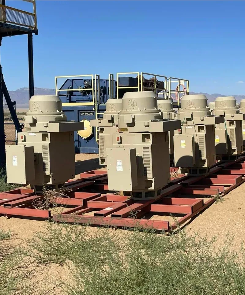 Row of distribution transformers on steel racks in a yard — Devine, TX